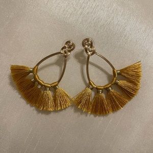 A stylish, never worn pair of fringe, hanging earrings, gold in color.